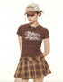 Close-up of retro mountain print t-shirt with plaid mini skirt and vintage accessories