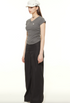 Side profile of model in gray v-neck tee and black pants, styled with white military cap and minimalist choker necklace