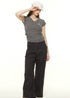 Model adjusting white cap wearing gray ruched t-shirt and black wide-leg pants, showcasing casual urban style