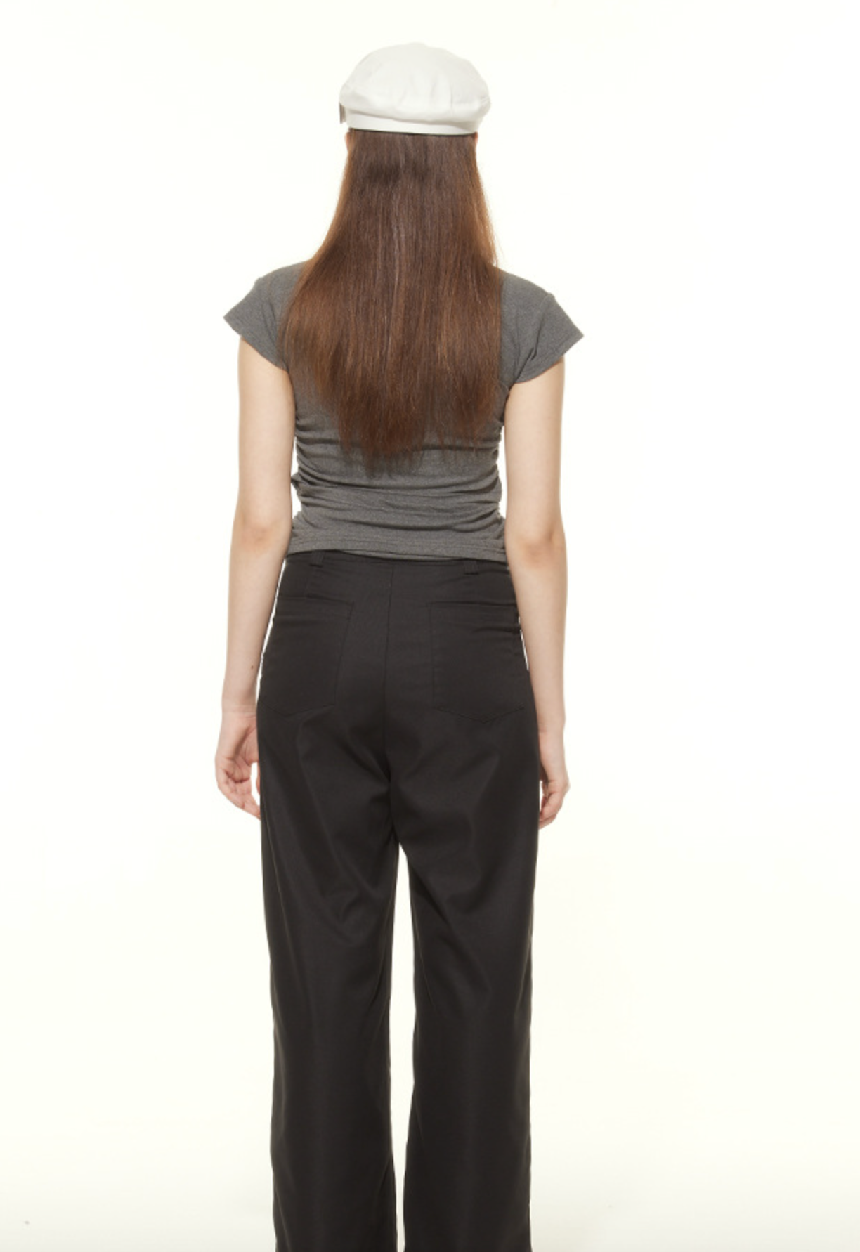 Back view of gray ruched t-shirt and black wide-leg pants outfit, showcasing casual streetwear styling with white cap