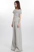 Side view of model in light gray draped top and wide-leg pants, wearing glasses
