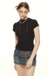 Close-up portrait of model in black t-shirt with pearl necklace and vintage glasses, showing edgy casual styl