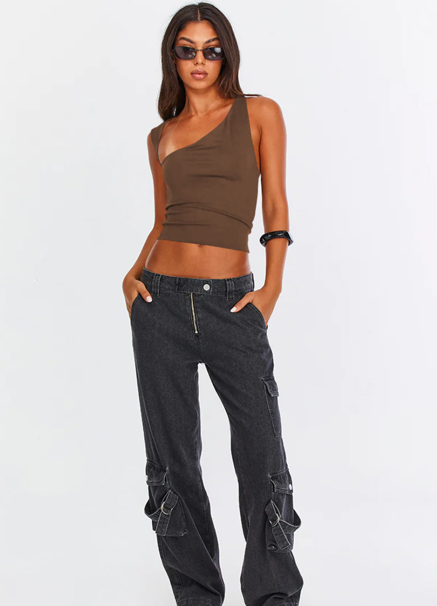 Brown asymmetrical one-shoulder top with cargo jeans, styled with sunglasses and white sneakers