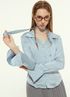 Woman in light blue blouse, holding choker, glasses, gray pleated skirt
