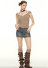 A woman wearing a taupe ribbed crop top with cross pendant necklace poses with hands on hips, styled with denim mini skirt and boots