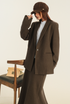 Styled brown suit set with white button-up shirt and vintage-inspired accessories