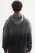 Back view of model in grey-to-black gradient hoodie with drop shoulders showing ombre effect, against white background