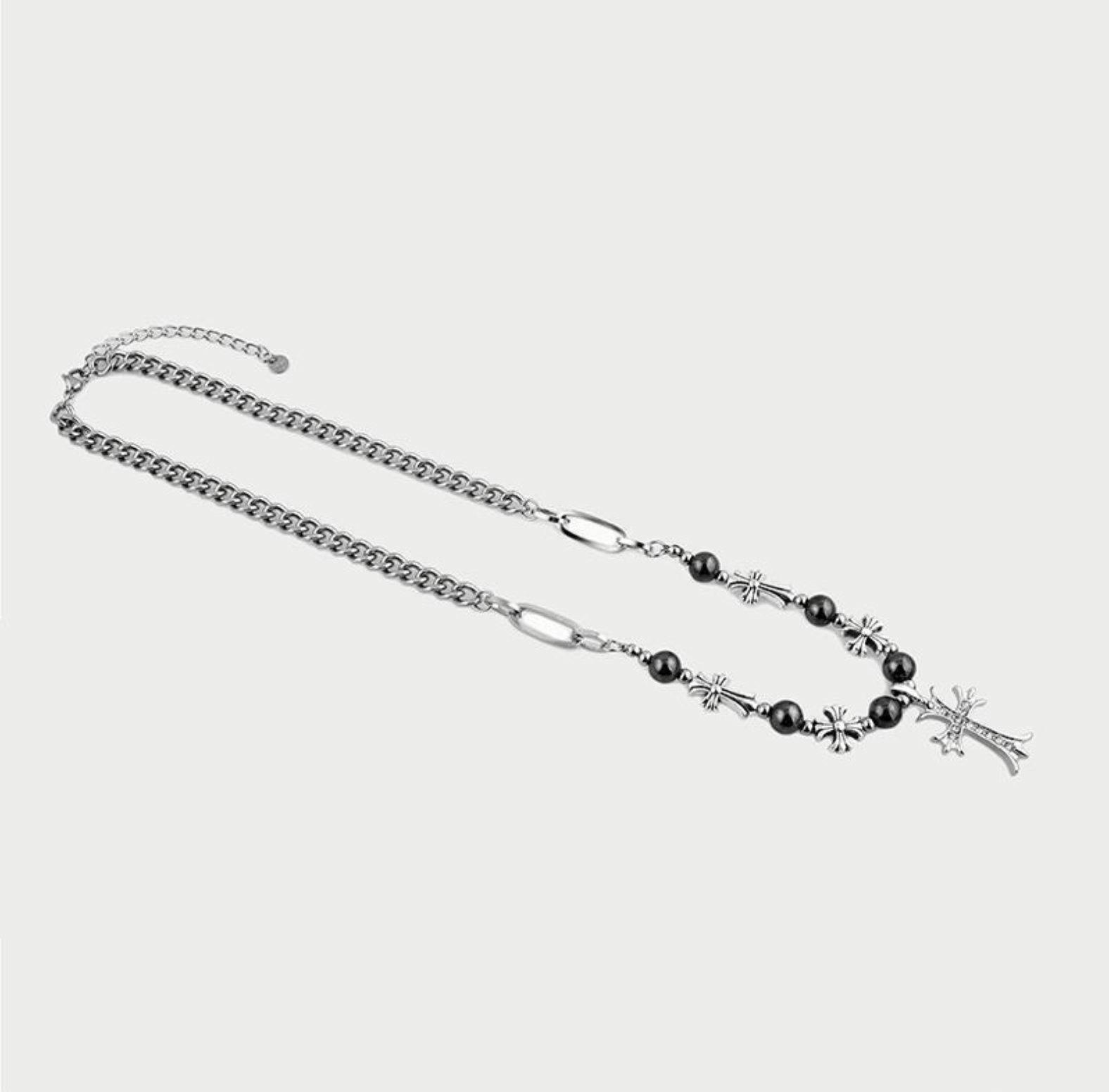 Silver necklace with black beads and star charms on a light gray background