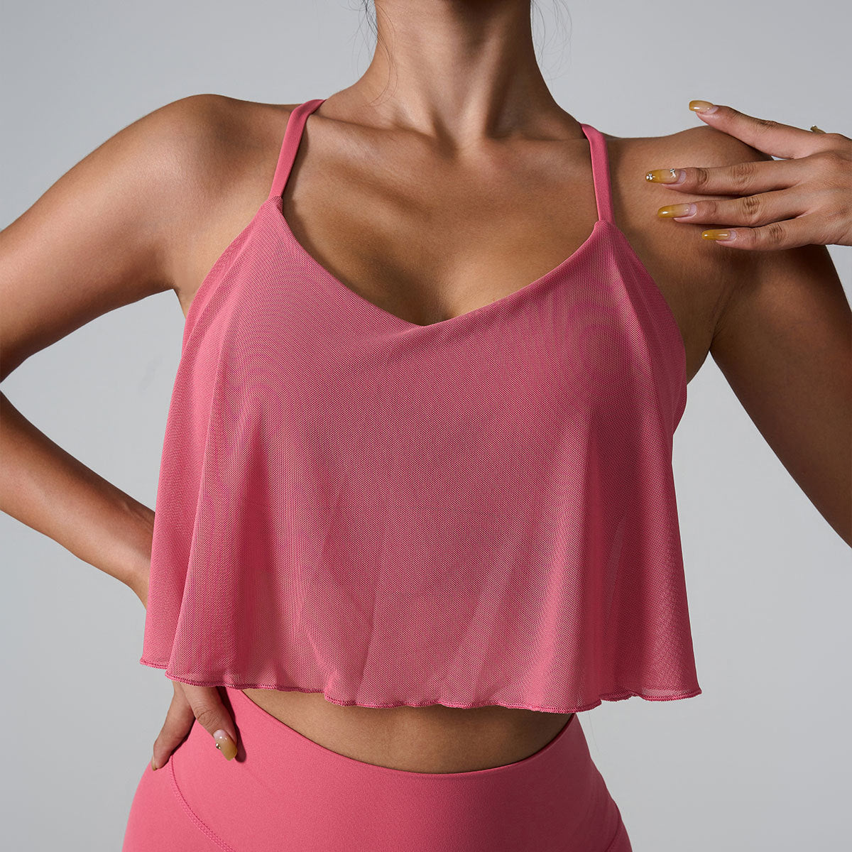 Front view of pink cropped camisole showing flowy overlay and spaghetti strap design
