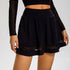 Close-up of black athletic skirt with sheer mesh panel trim and high-rise waistband design