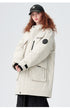 A woman with curly red hair wearing NY cap models cream Be_Born parka with black sleeve patch against white background