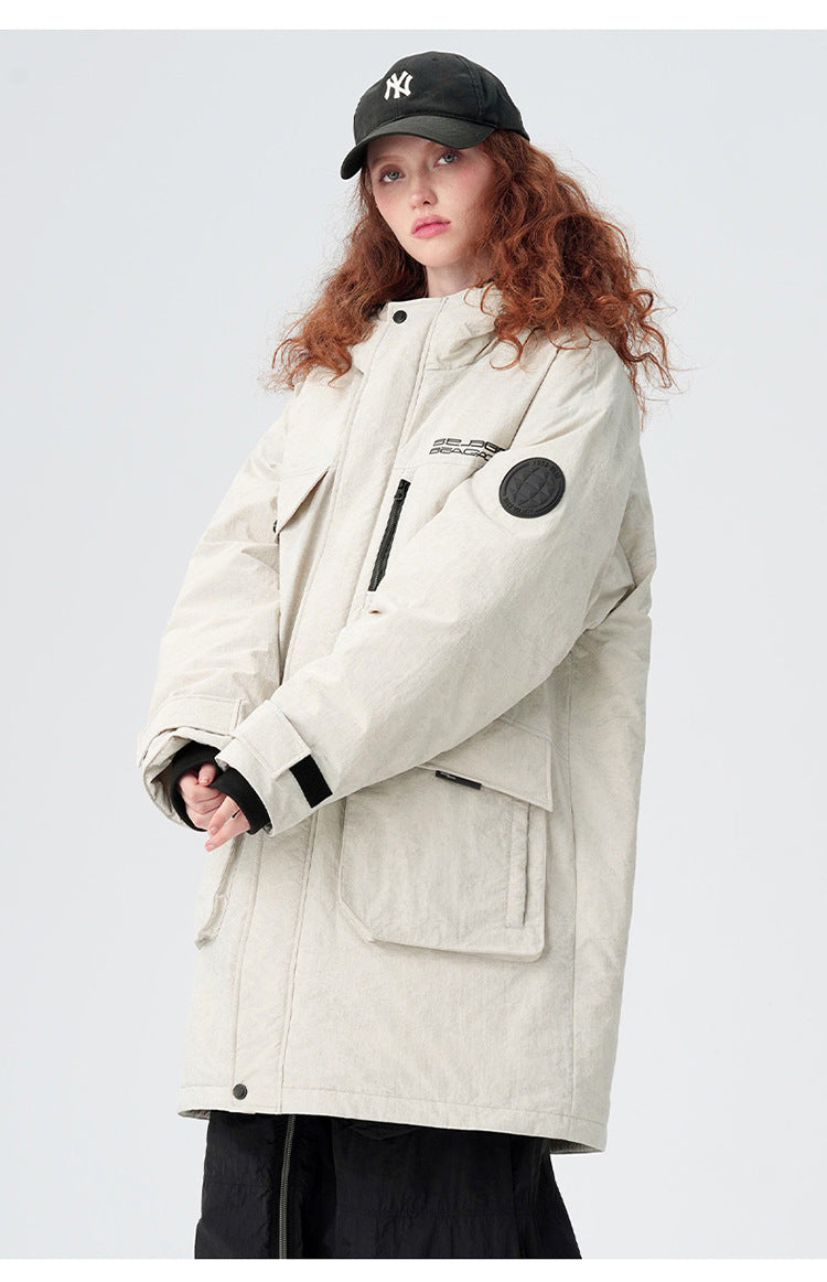 A woman with curly red hair wearing NY cap models cream Be_Born parka with black sleeve patch against white background