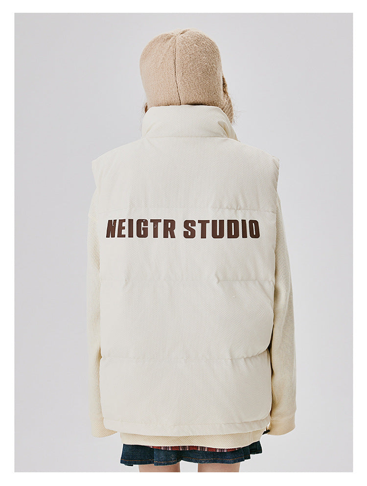 Back view of cream puffer jacket with brown NEIGTR STUDIO text across shoulders, worn with beige knit beanie against white background