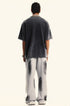 Back view of model showing charcoal oversized t-shirt and gray tie-dye sweatpants with paint splotch pattern