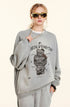 Close-up of female model wearing gray sweatshirt with Winding Decoration graphic, gold sunglasses, gold chain, hand touching necklace, profile angle