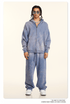 Washed blue-gray zip hoodie and baggy matching pants, model with twisted hair, sunglasses, silver jewelry, white sneakers
