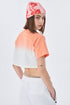 Profile of model in coral ombré crop top, tie-dye beanie, layered necklaces
