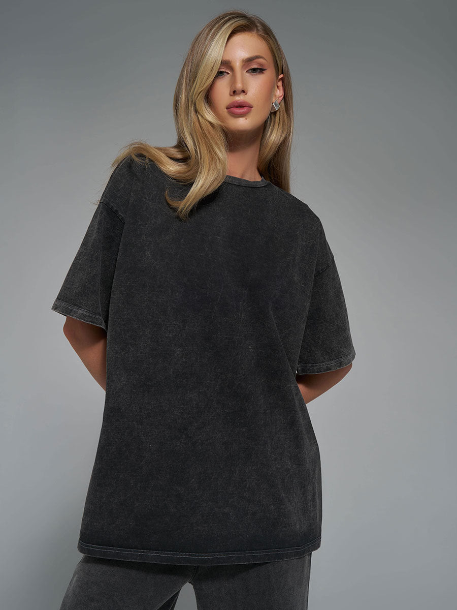 Woman wearing a black t-shirt against a gray background