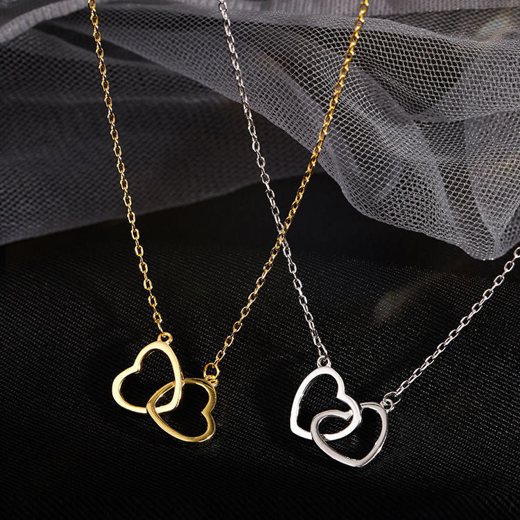 Two delicate heart-shaped pendants on gold and silver chains, displayed on a mesh and textured background
