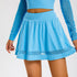 Detail of blue athletic skirt highlighting A-line silhouette and mesh trim design
