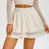 White apricot sports skirt with mesh panel detail and high-rise waistband, showing flared silhouette