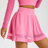 Pink athletic skirt featuring high waistband and mesh trim panels for style and ventilation