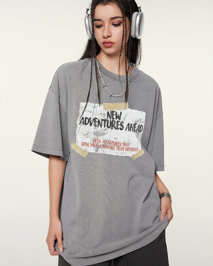 Close-up of gray t-shirt with motivational "New Adventures Ahead" text design and silver chain necklace