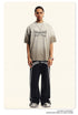 Breaking Tradition oversized gray tee with gothic text design, styled with black trackpants and silver chain necklace