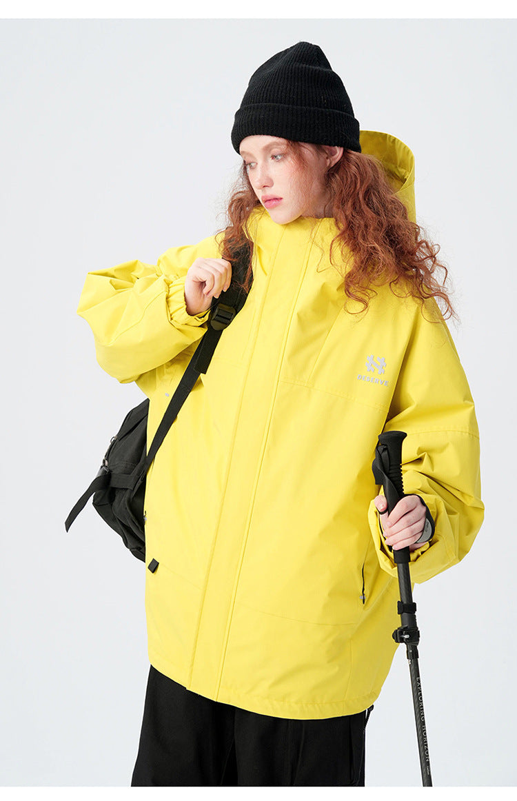 Urban outerwear collection featuring ski pole accessory and contrast color combinations, showing versatile outdoor functionality