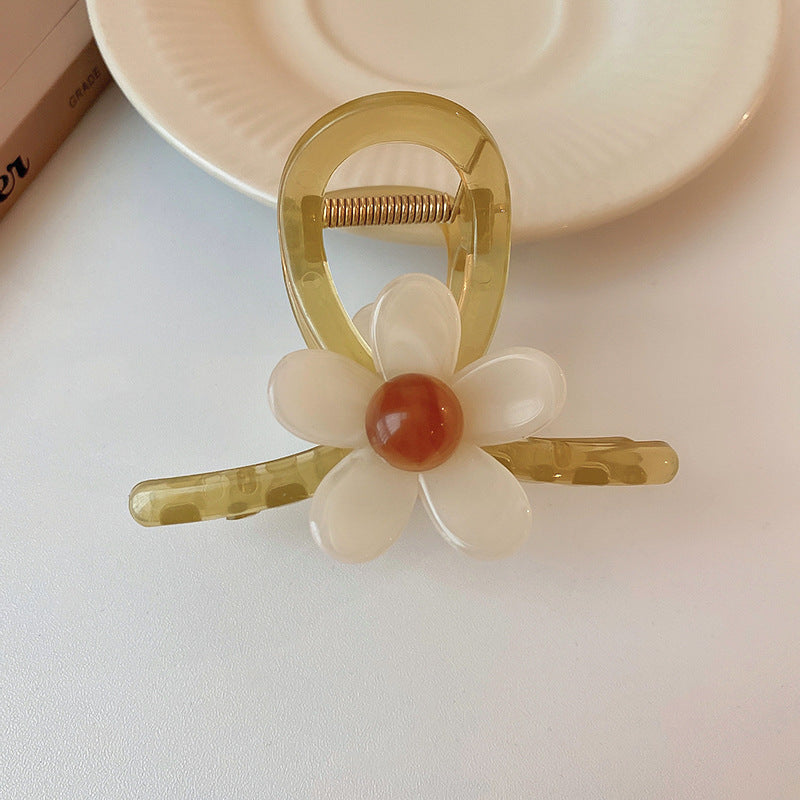 A dainty light green hair claw featuring a flower with a glossy finish, displayed on a white surface.