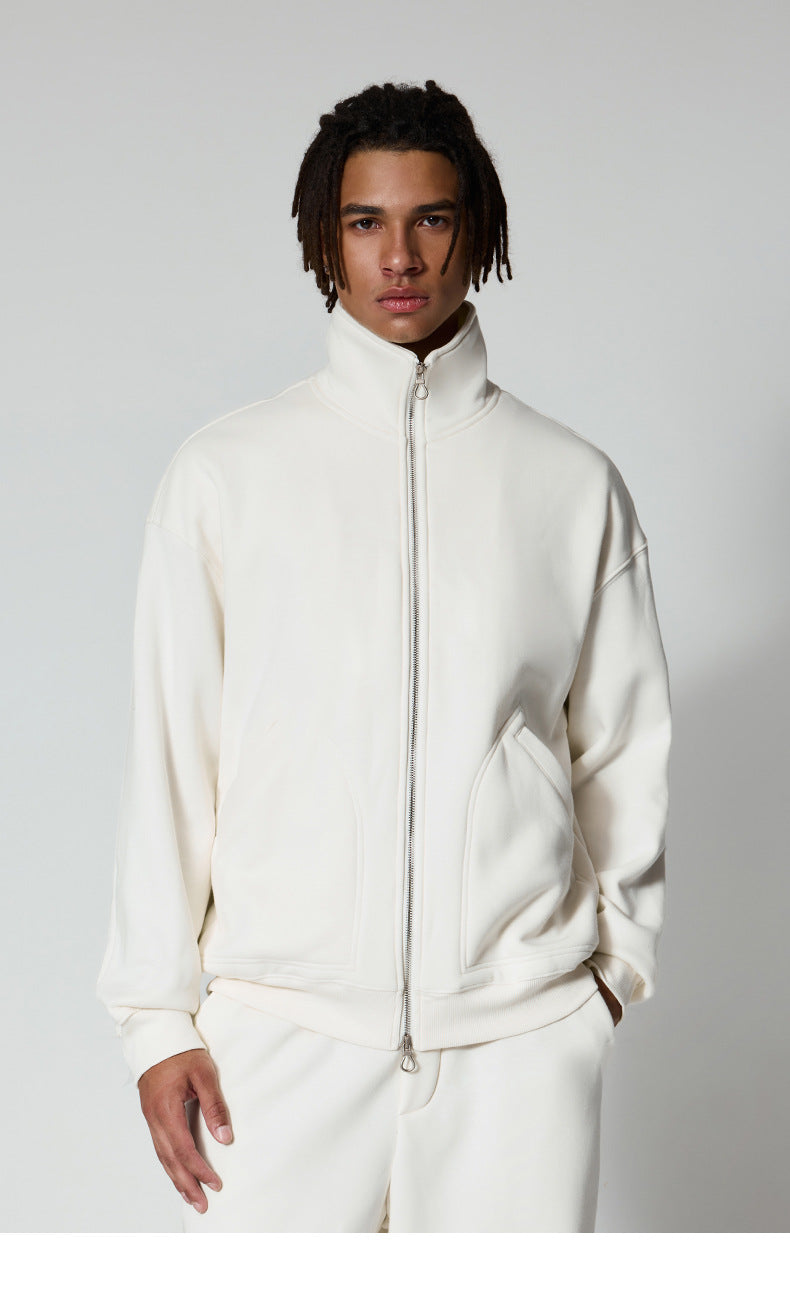 Minimalist white track jacket with high collar, silver zipper, and relaxed fit, shown on model with locs