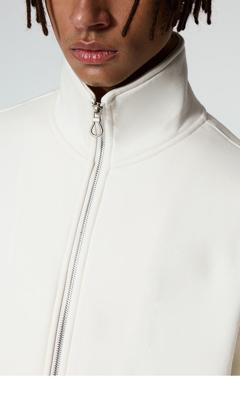 Close-up detail of silver zipper pull and high collar construction on white track jacket