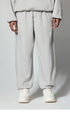 Light gray sweatpants with elastic waistband, paired with white chunky sneakers, shown from waist down