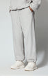 Gray sweatpants with side pockets, styled with white chunky sneakers, photographed from waist down