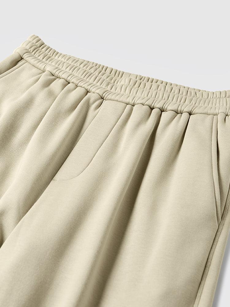 Light gray sweatpants with elastic waistband and gathered ankle, worn with white chunky sneakers