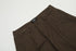Close-up detail of brown cargo pants waistband showing Titan Brand label and button closure against white background