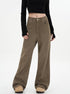 A woman standing wearing high-waisted olive-brown wide-leg pants with classic 5-pocket styling, paired with a black crop top and beige platform boots