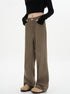 A woman with hands in pockets modeling olive-brown wide-leg pants with high waist, black crop top with thumb holes, and beige platform boots