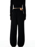 A back view of woman wearing black wide-leg pants showing brand label on waistband, black crop top exposing midriff