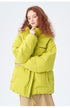 Female model showcasing yellow Impressionism puffer jacket with beige pants