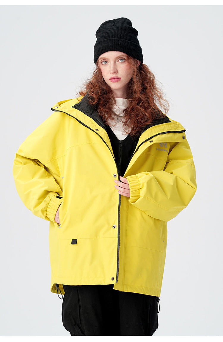 Portrait shot of yellow waterproof jacket with black beanie, demonstrating layered winter styling