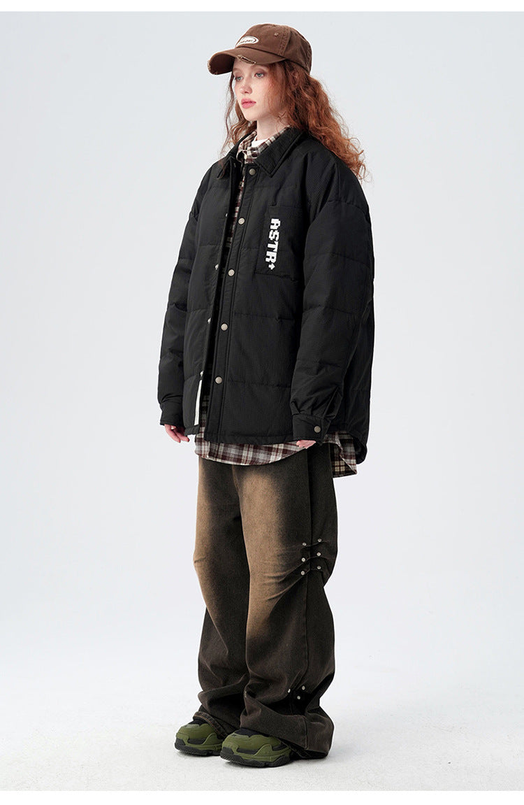 Model in side profile wearing black ASTROSMASH puffer jacket with plaid shirt, brown cap and wide-leg pants with green shoes