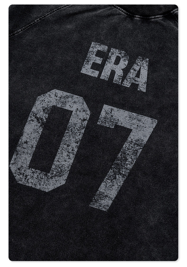Close-up of distressed 'ERA 07' print detail on black fabric