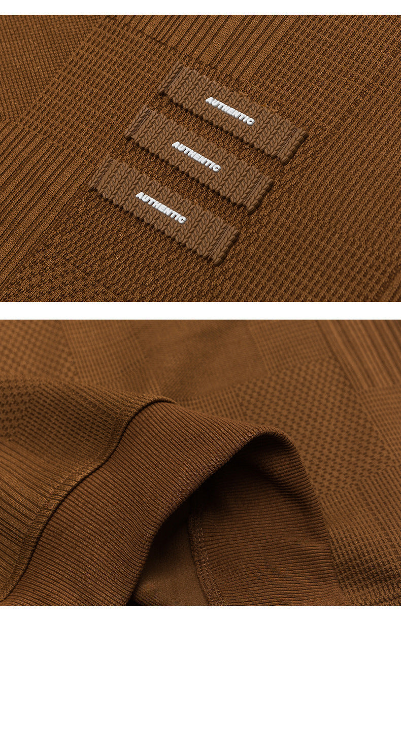 Close-up detail of brown textured sweatshirt showing three "AUTHENTIC" tabs and fabric texture
