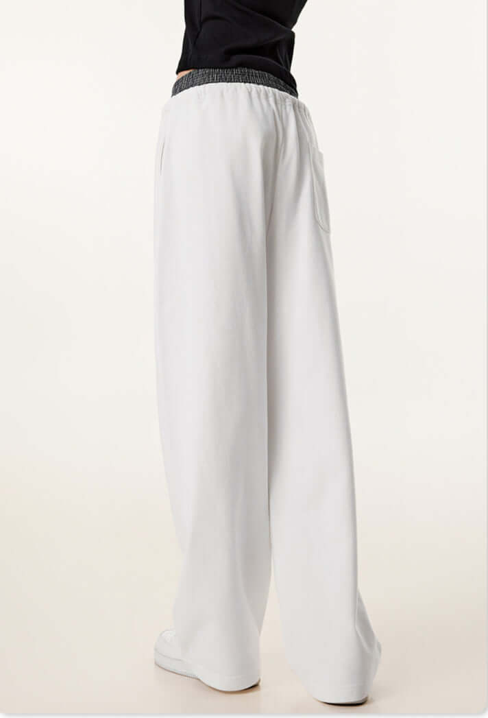 Rear view of white sweatpants, showing the relaxed fit, elastic waistband, and a single back pocket.
