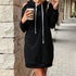 Black cold-shoulder hoodie dress with white drawstrings, styled with coffee cup for casual urban streetwear