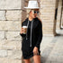 Trendy black hoodie dress with white hat, sunglasses, and coffee, showcasing stylish cold-shoulder design