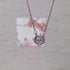 Macro shot of silver cat pendant featuring pink crystal center and whisker details