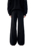 Back view of black wide-leg pants with panel construction and flared silhouette