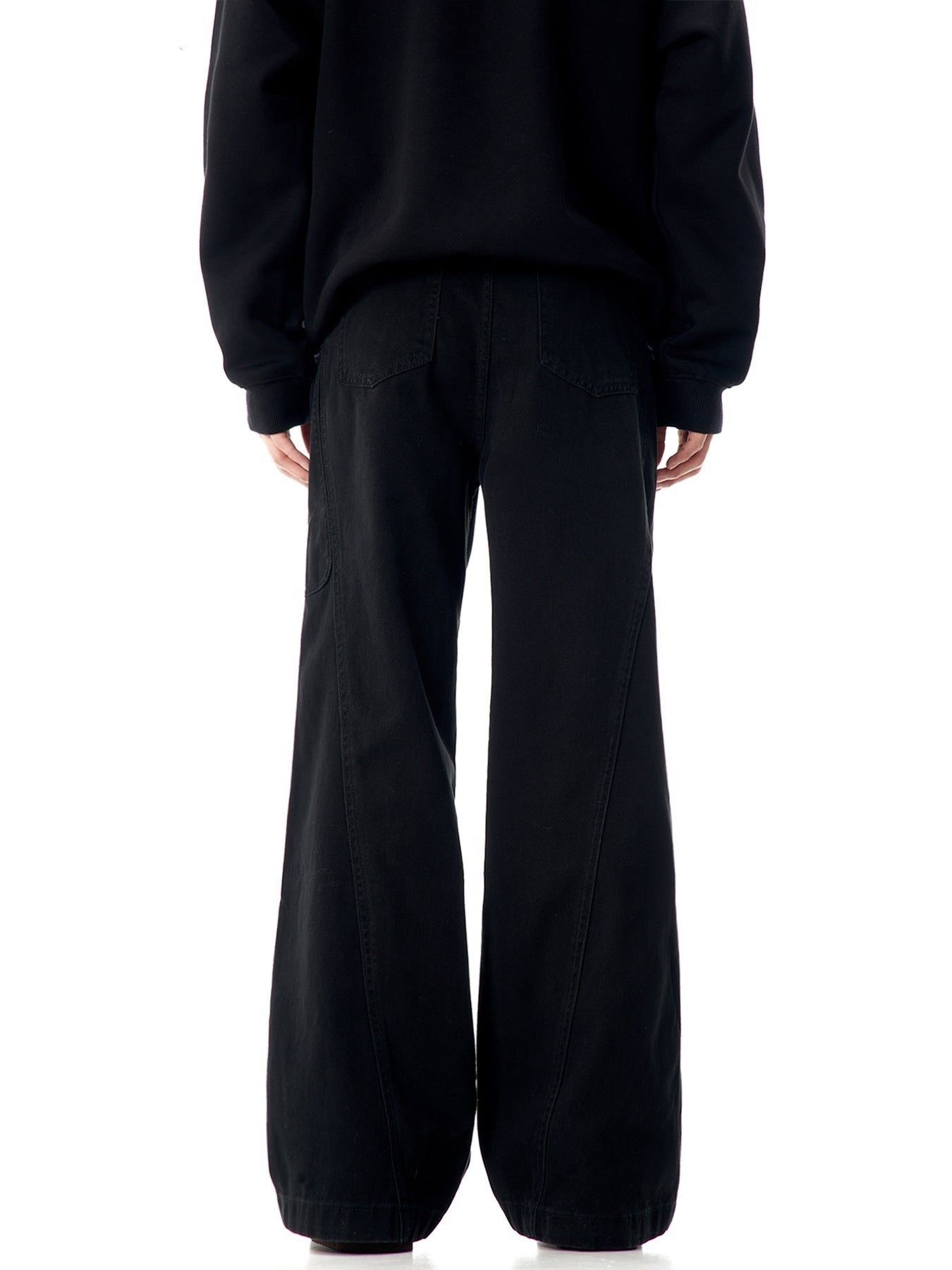 Back view of black wide-leg pants with panel construction and flared silhouette